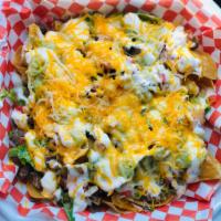 Super Nachos · Fresh tortilla chips topped with refried beans, your choice of meat, pico de gallo, guacamol...