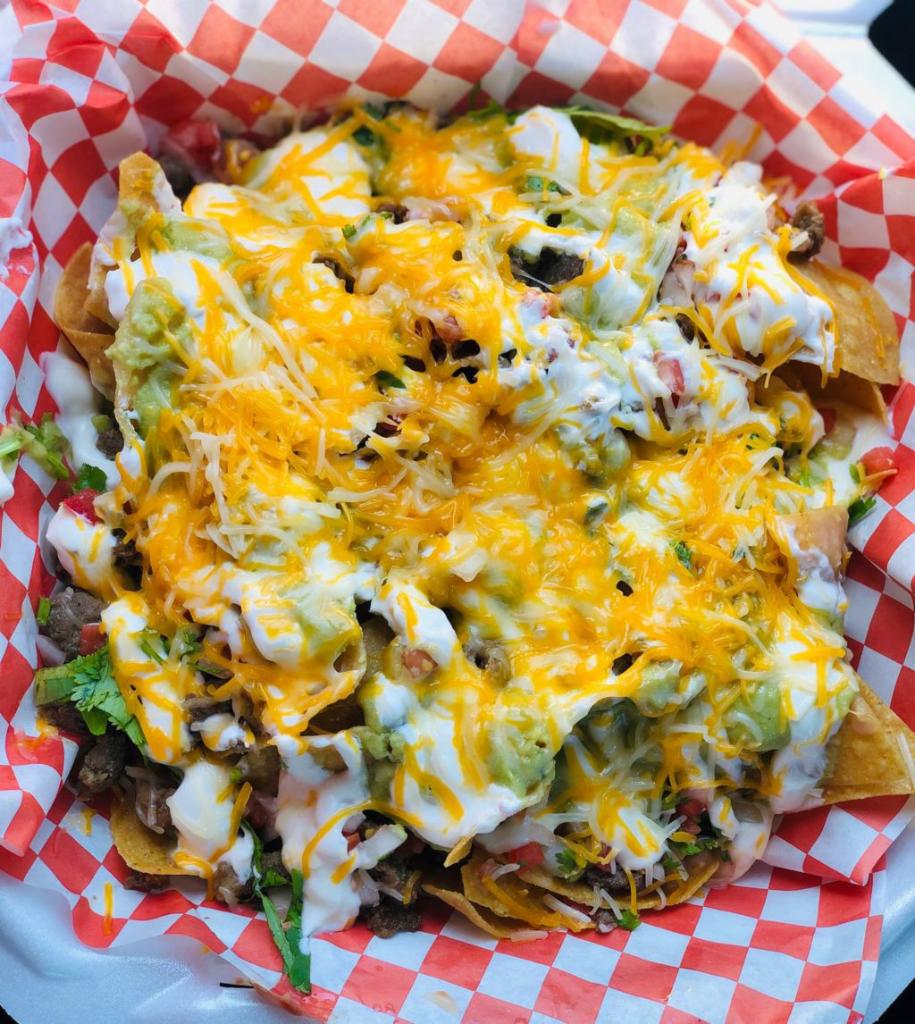 Super Nachos · Fresh tortilla chips topped with refried beans, your choice of meat, pico de gallo, guacamole, sour cream, shredded cheese and jalapenos.