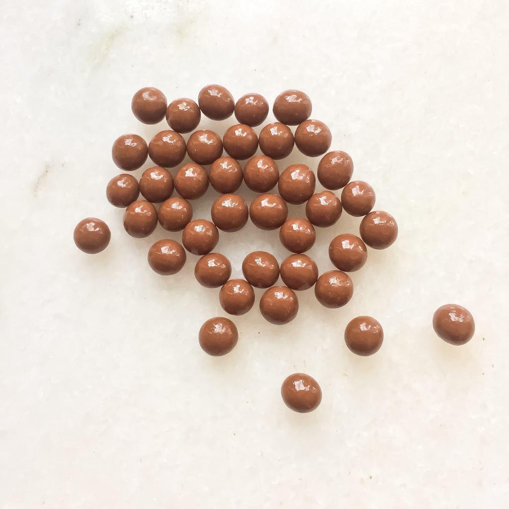 Milk Chocolate Crunchy Pearls · Toasted puffed cereal enrobed in caramelized 36% milk chocolate. Note: contains wheat and milk.