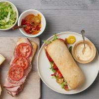 The Italian Sandwich · Salami, ham, provolone cheese, pickled eggplant, marinated peppers, tomato, romaine, and car...