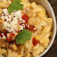 The Elote Mac · Bowl of traditional gooey mac and cheese, garnished with savory Mexican street corn, crumble...
