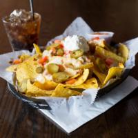 Mexican Nachos · Fresh fried tortilla chips loaded with ground beef, white queso, tomatoes, onion, jalapenos ...