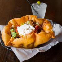 Taco Salad · A large fried tortilla shell filled with leafy greens, ground beef, cheddar cheese, tomatoes...