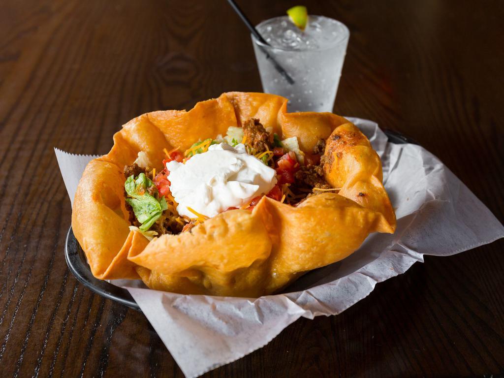 Taco Salad · A large fried tortilla shell filled with leafy greens, ground beef, cheddar cheese, tomatoes, sour cream and fresh salsa.