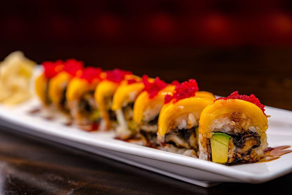 Golden Dragon Roll · Eel and avocado roll wrapped in mango slices, topped with tobiko and kabayaki sauce.