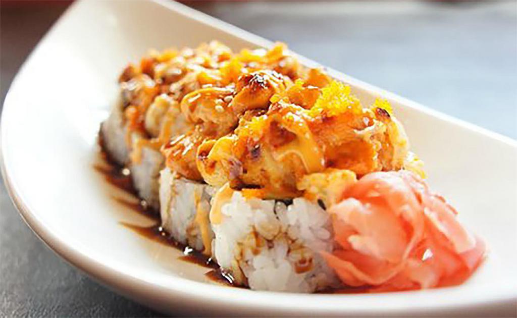 19. TNT Roll · Crabmeat, avocado topped with torched tuna, salmon, crab salad and masago.
