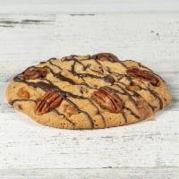 Turtle Cookie · A Texas favorite! Our chocolate chip cookie topped with caramel bits and pecans, and then dr...