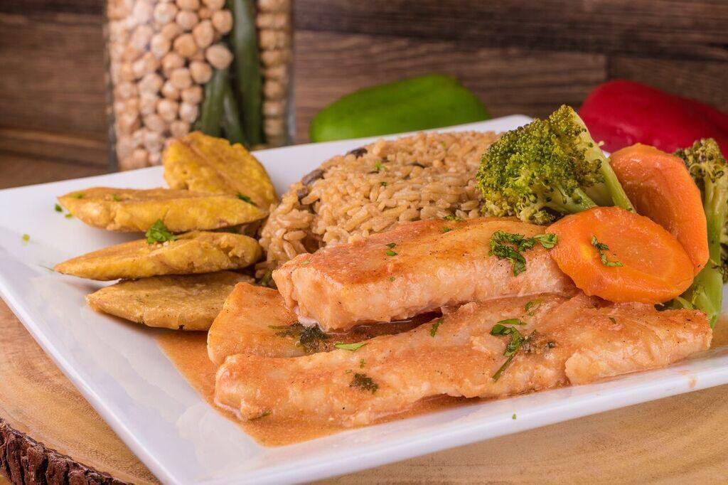 Pescado Guisado / Stew Fish · Stewed tilapia fish in a tomato-based sauce served with two sides 