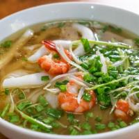 P6. Seafood Pho Noodle Soup · Grilled shrimps, squid and Crab meat, with rice noodles, served with chicken broth soup, oni...