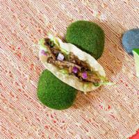 Short Rib Taco · Short rib, shredded cabbage slaw, scallions, sesame seeds, and diced onion on a torilla.