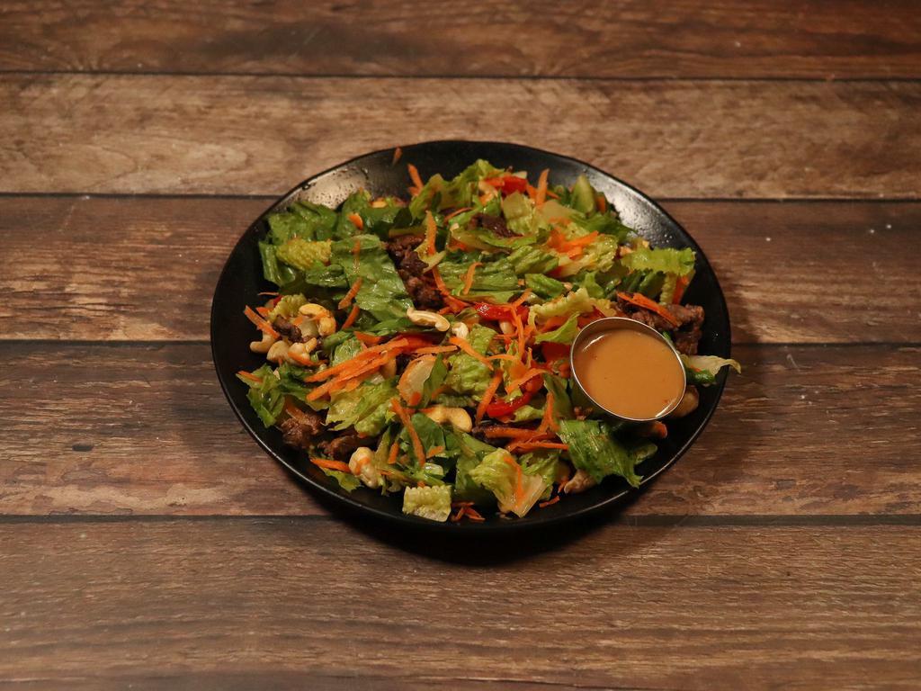 240. Sesame Ginger Beef Salad · Grilled seasoned skirt steak and strips with red pepper. Served over chopped romaine lettuce, topped with shredded carrots and roasted cashews. Served with Asian sesame ginger vinaigrette. Choice of tossed or chopped.