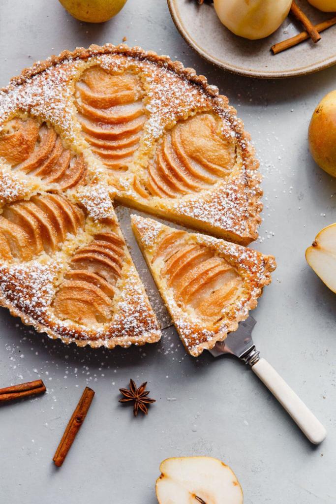 Fresh French Pear Tart Slice · This classic French poached pear tart is made with a sweet tart dough and filled with poached pears and frangipane (almond cream). Serve over the holiday season for a special treat! 