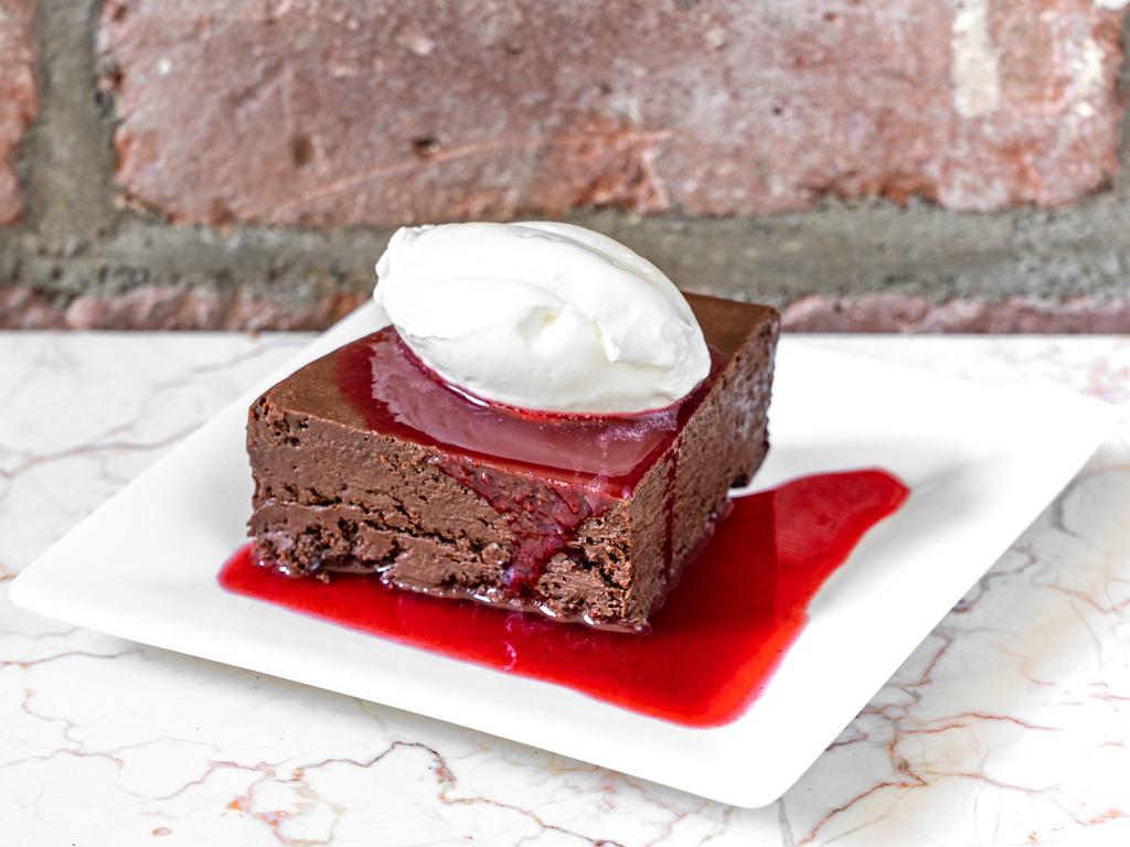 Flourless Chocolate Cake · Made with 70% Peruvian chocolate. Served with decadent raspberry  sauce, topped with fresh whipped cream.