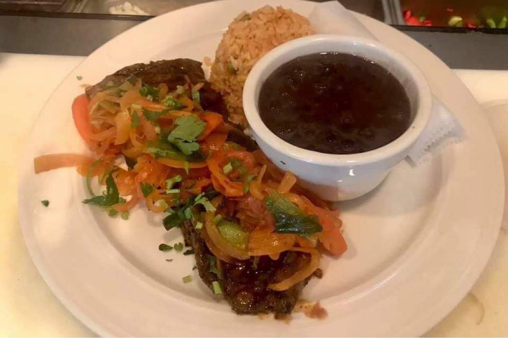 Bistec Encebollado · 8 oz. skirt steak, onions scallions and, tomatoes served with rice, black beans and, tortillas.