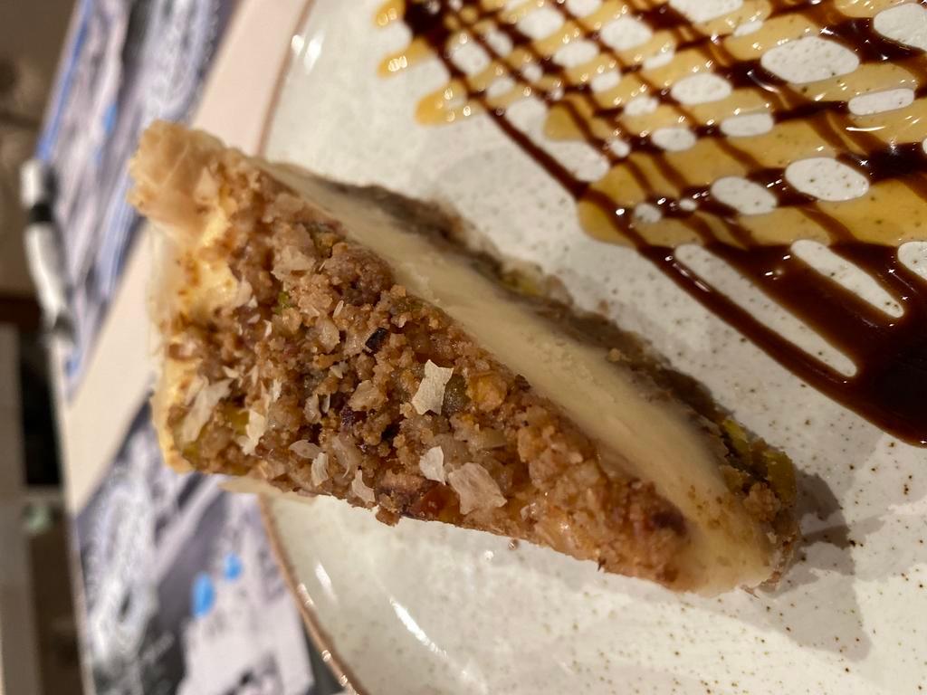 Baklava Cheesecake · A flaky buttery filo base,topped with a perfect honey and nut baklava filling,with ample velvety smooth cream cheese,garnished with more baklava filling