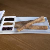 Cinnamon Churros · Spicy Mexican chocolate, Dulce de leche and raspberry dipping sauces.