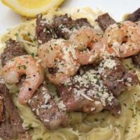 Surf ＆ Turf Alfredo · 8 large shrimp and Sirloin steak laid on top of a bed of our signature fresh fettuccine nood...