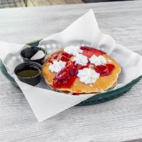 Berry Bliss Pancakes · 2 pancakes, strawberry topping, whipped cream, warm maple syrup, butter, and powdered sugar.
