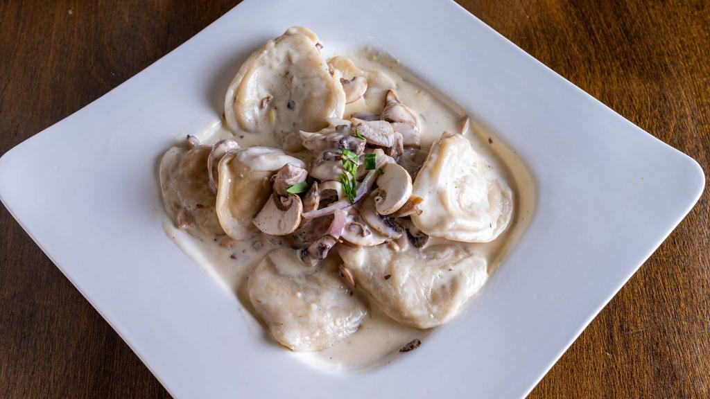 Cheese Ravioli Bianco · Ricotta cheese ravioli 6pieces, red onions, mushrooms, creamy Parmesan sauce. Extras for an additional charge.