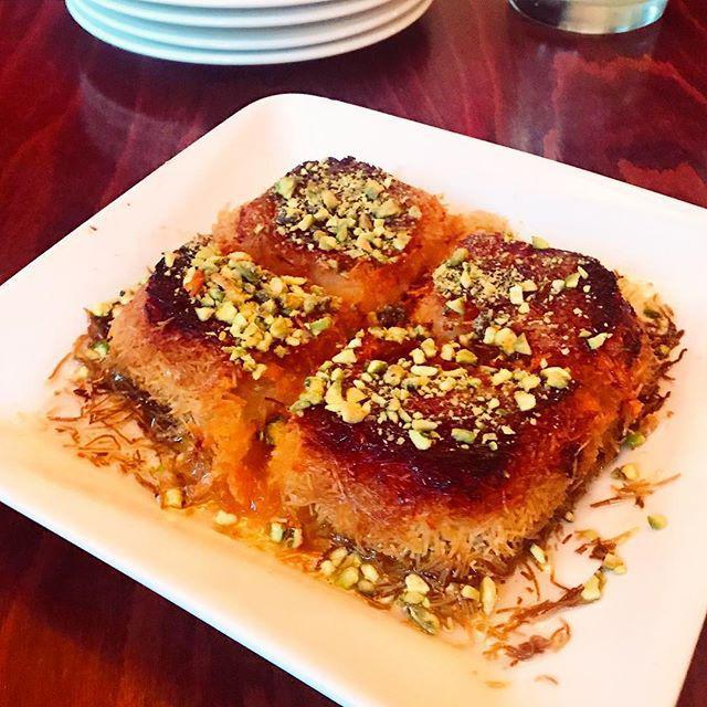 Knafeh · A house specialty, knafeh is crispy layers of filo dough & sweet cheese, baked then soaked in orange blossom syrup and with pistachios. 
TAKE & BAKE: syrup, pistachio, & instructions on the side.
