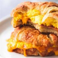 Buttery Croissant Breakfast Sandwich  · Cheesy scrambled eggs, sliced ham and or bacon, sharp cheddar cheese, on buttery croissants. 