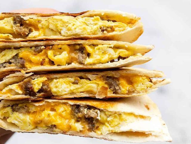 Breakfast Quesadilla · Flour tortillas stuffed with 2 scrambled eggs, melted cheese, peppers & onions, hot salsa and your choice of Sausage, ham or bacon

