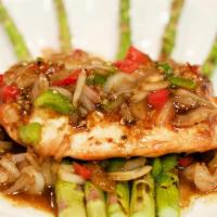 Garlic Salmon · Grilled Atlantic salmon fillet served over a bed of asparagus spears, topped with chopped sh...