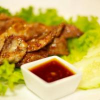 Grilled Pork · Thai-style marinated pork with black pepper, cilantro and garlic served with homemade sauce.