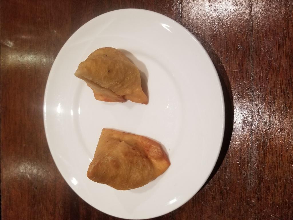 Chicken Samosa · A triangle of shaped pastry stuffed with lightly spiced chicken mince, diced potatoes, green peas, herbs, and deep fried.