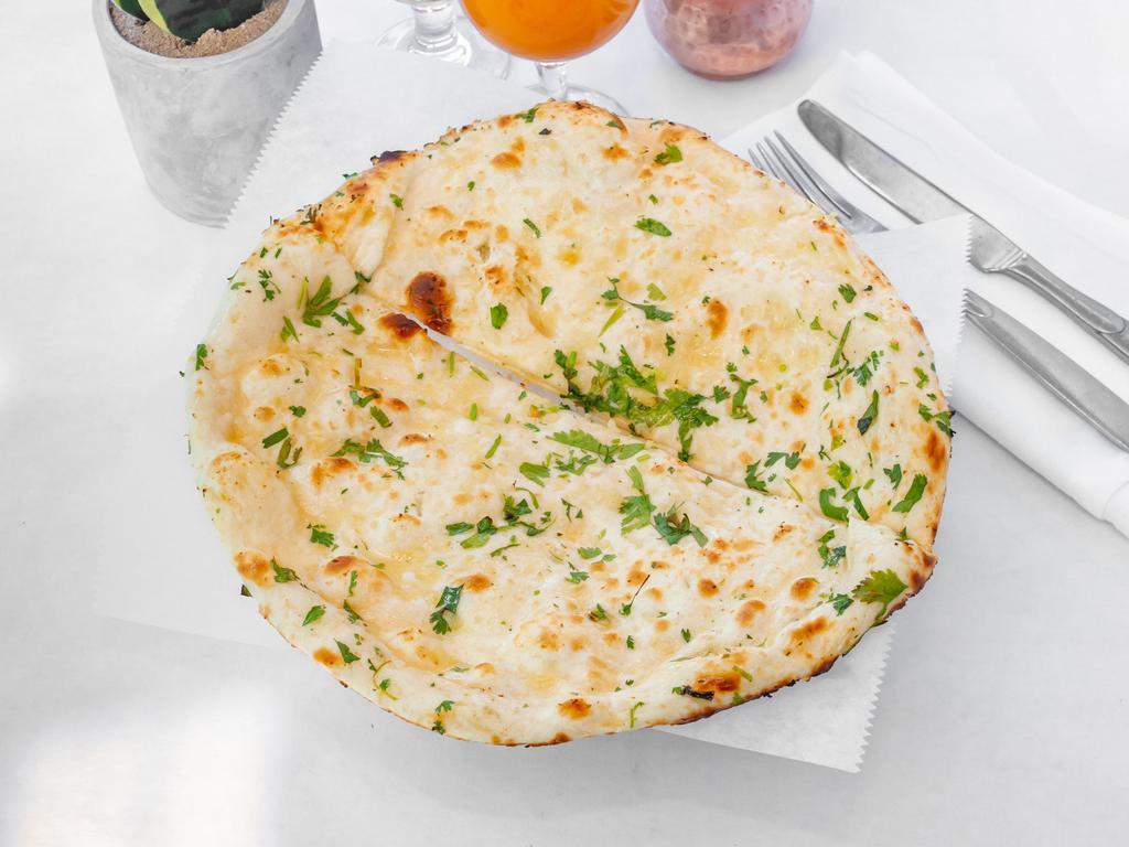 Garlic Nan · Leavened white flour bread basted with fresh garlic coriander and baked in a tandoor.