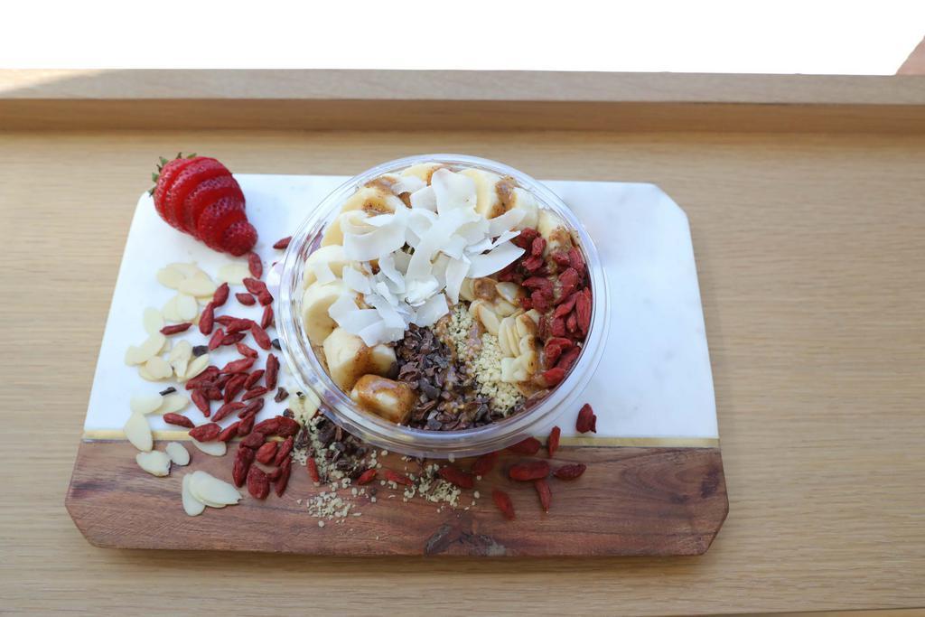 Superfood Edge Acai Bowl · Acai topped with banana, almond slices, goji berries, coconut flakes, cacao nibs, hemp seeds, almond butter, granola.