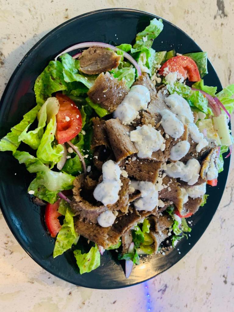 Gyro Salad  · Romaine lettuce, tommatoes, onions, cucumbers, olives and pickles tossed in our in-house dressing topped with gyro meat and taziki sauce.  