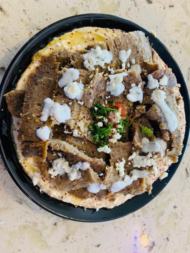  Hummus and Meat Plate · Chicken shawrma or lamb and beef Gyro over Hummus and topped with a choice of tahini, taziki or spicy sauce.   