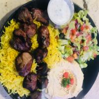   lamb Skewers plate ·   Skewers of lamb  served with rice,bread, hummus and salad.  