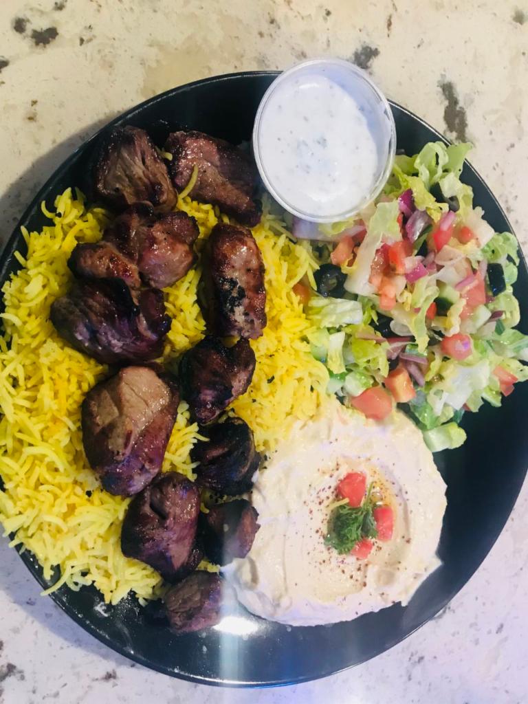   lamb Skewers plate ·   Skewers of lamb  served with rice,bread, hummus and salad.  