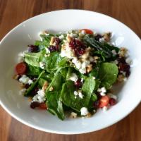 Krinti Health Salad · Baby spinach, tomatoes, cranberries and walnuts topped with goat cheese and pomegranate oliv...