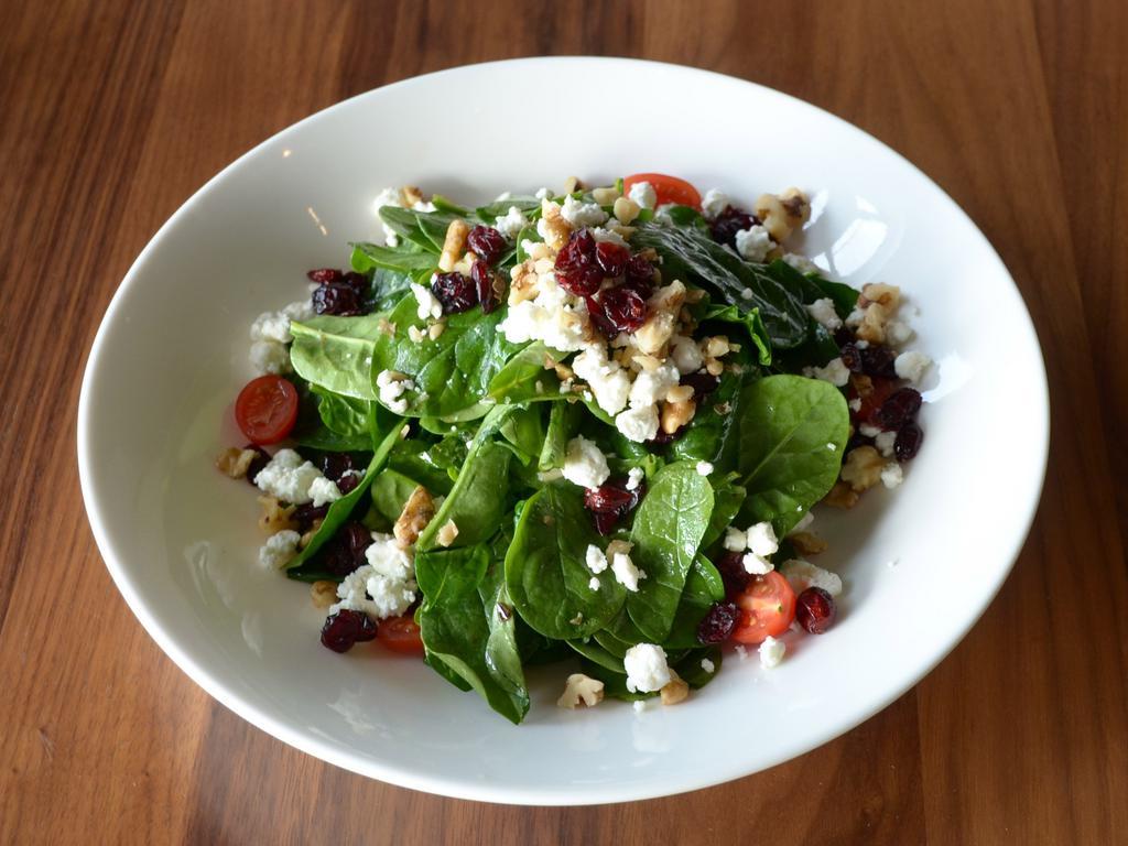 Krinti Health Salad · Baby spinach, tomatoes, cranberries and walnuts topped with goat cheese and pomegranate olive oil dressing.