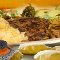 Carne Asada · Steak, fried onions, fried jalapenos, avocado, tomato, pico de gallo, rice and beans.