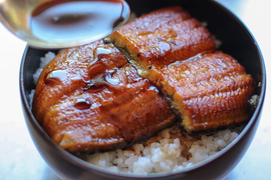 Unagi Don · 6 pieces of Japanese style marinated and toasted eel over rice, comes with 3 kinds of osinkos (Japanese pickles - Green, red and yellow) Served with miso soup or salad.