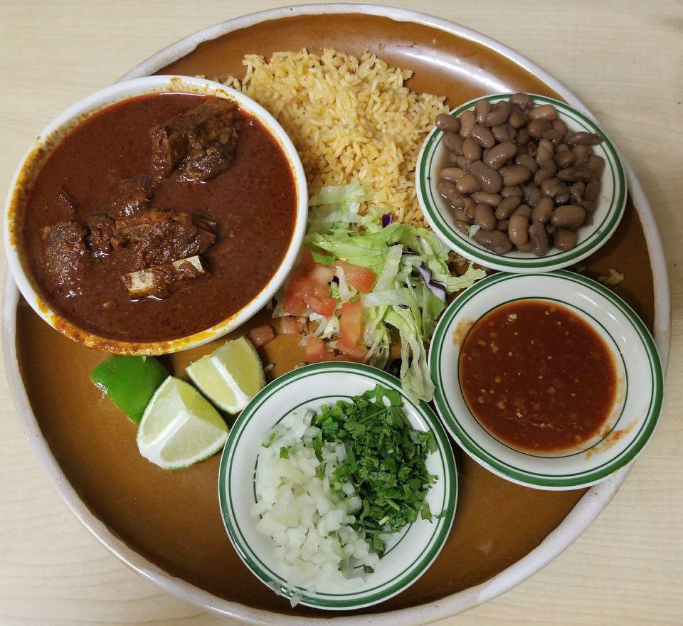 BIRRIA DE RES · Chunks of beef in a mild chile california sauce
served with rice, rancho beans cilantro and diced onios