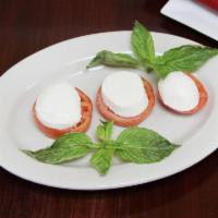 Caprese Salad · Sliced mozzarella cheese, heirloom tomatoes and basil drizzled with extra virgin olive oil. 