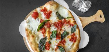 Traditional Margherita Pizza · Fresh homemade mozzarella and San Marzano tomatoes.