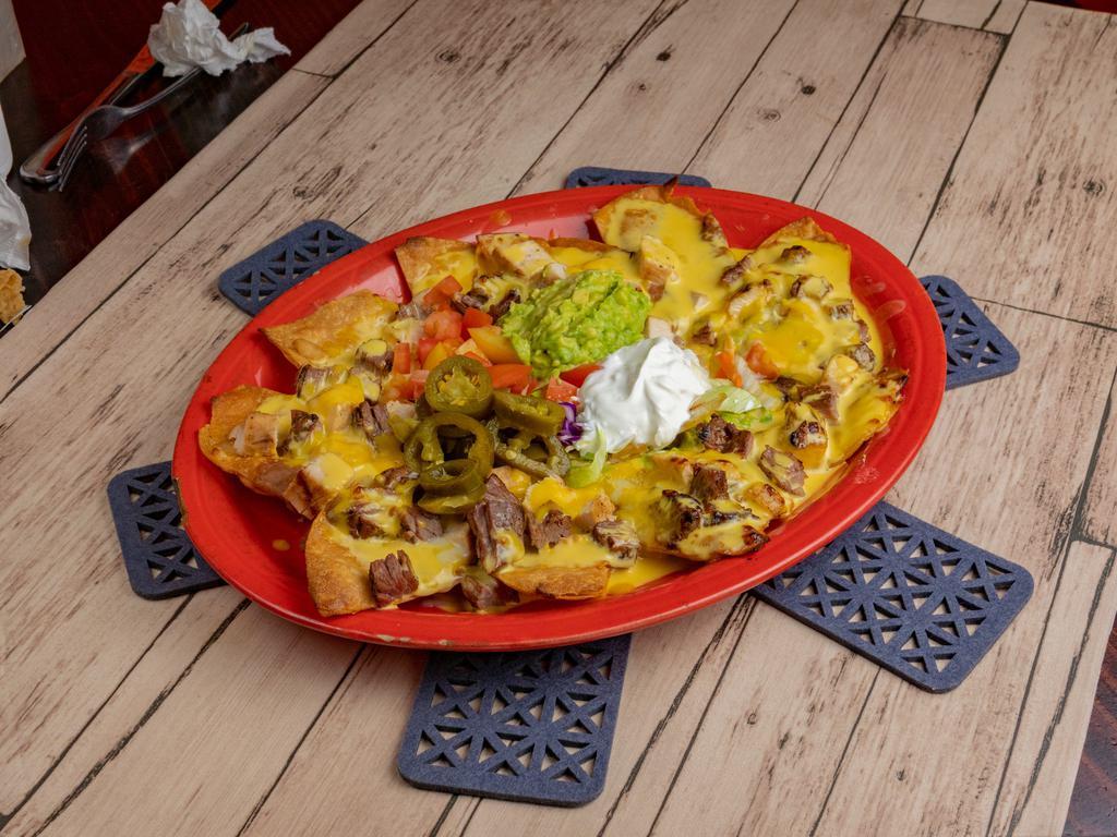 Nachos Bonitos · Corn tortilla chips topped with re-fried beans. Your choice of beef or chicken fajita, melted American cheese and chile con queso on top. Served with guacamole, sour cream and jalapenos.