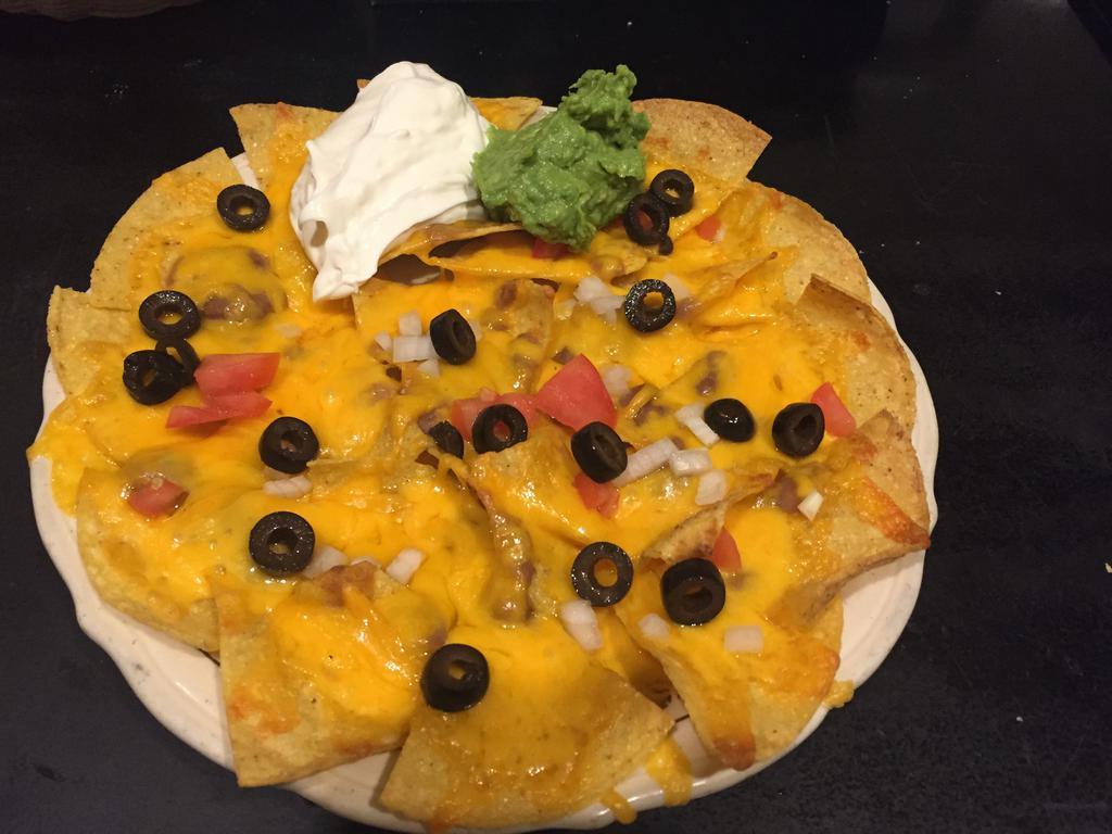Nachos · Chips with cheese, beans, onions, tomatoes, olives, sour cream and fresh guacamole. Add beef or chicken for an additional charge.