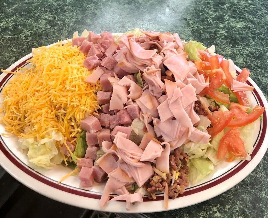 Chef Salad · Mixed greens, carrots, red cabbage, eggs, croutons, tomatoes, chopped bacon, diced ham, sliced turkey and cheddar cheese. 