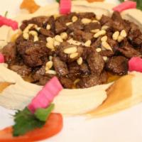 Hummus with Meat · Hummus topped with tender chopped beef and pine nuts.