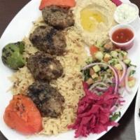 33. Grilled Kofte Kabab · Ground beef seasoned with spices. Served with homemade bread, rice, salad, red cabbage and t...