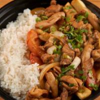 POLLO SALTADO · Peruvian stir-fried chicken with red onions, tomatoes, soy sauce, & cilantro, served with ri...