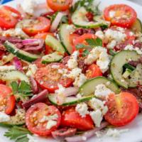 Horiatiki · Greek Island salad. Tomatoes, cucumbers, red onions, olives and fresh cheese tossed in olive...