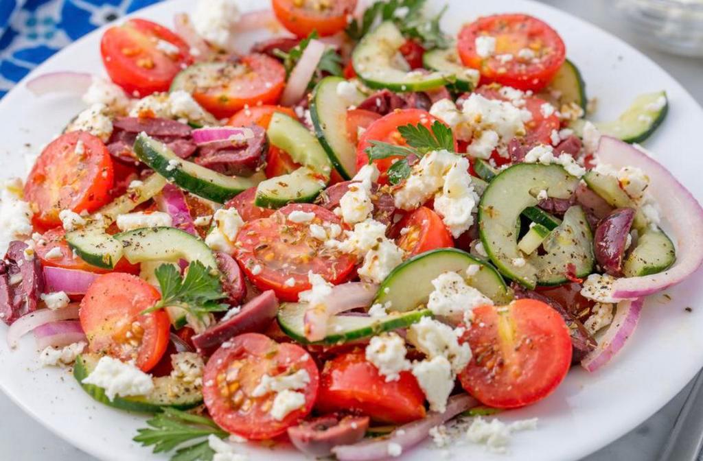 Horiatiki · Greek Island salad. Tomatoes, cucumbers, red onions, olives and fresh cheese tossed in olive oil.
